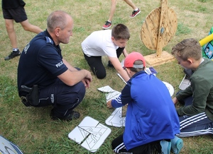 policjant pomaga dzieciom układać puzzle