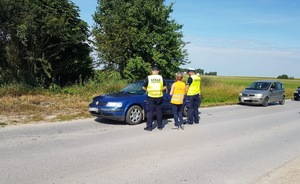 policjanci, samochód i przejazd kolejowy