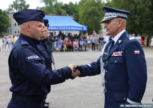 policjant otrzymuje gratulacje od komendanta